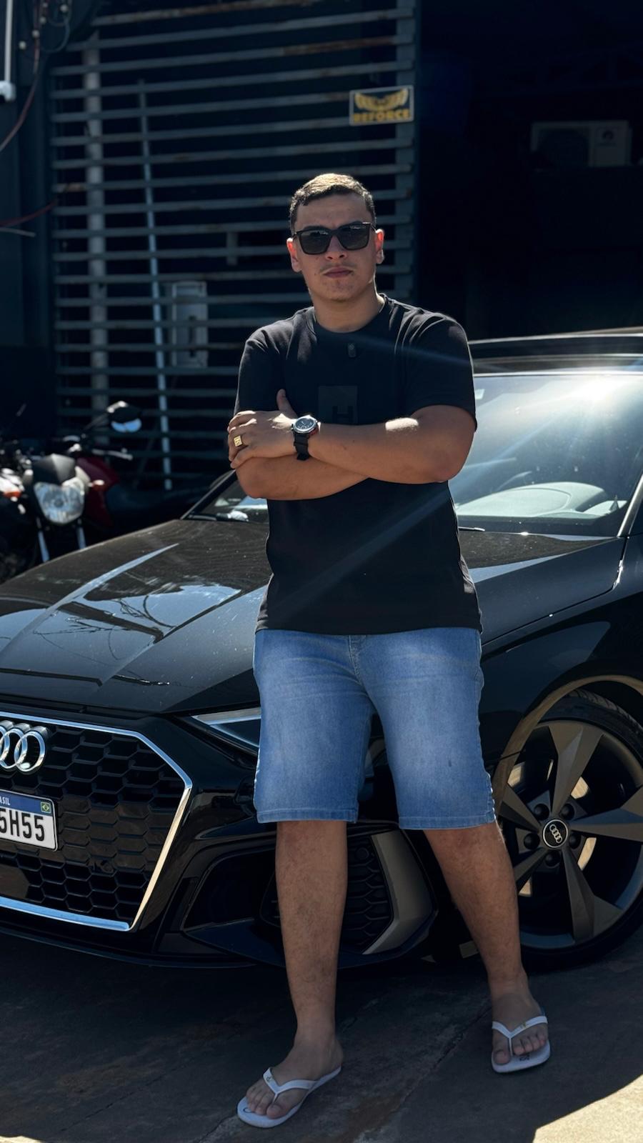 Kaiky Rocha ao lado de um veículo em frente à KR